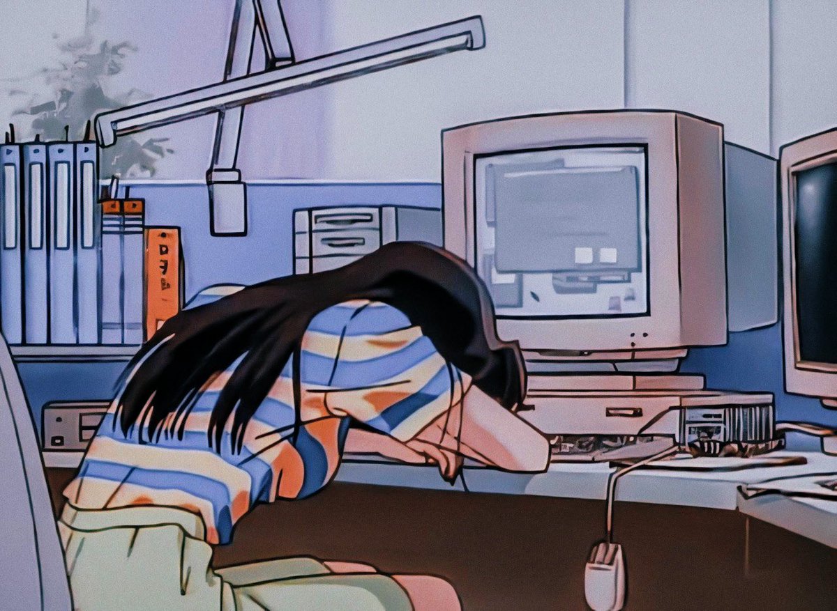 Girl sitting in front of a computer with her head down.